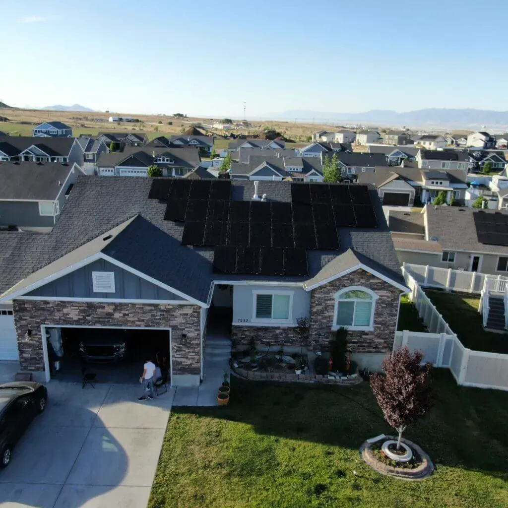 A sleek Lehi, Utah home with solar panels reflecting the midday sun, set against a backdrop of tech offices, symbolizing innovation and savings.