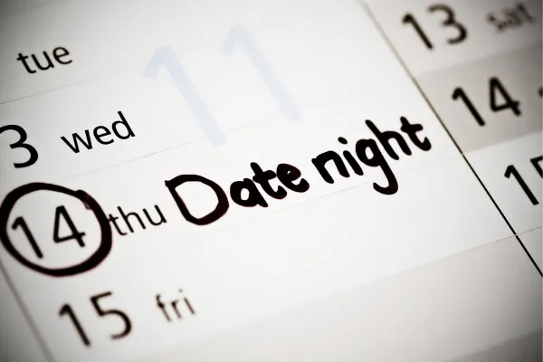 A calendar page with date night written in black marker on one of the dates.