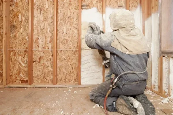 Spray foam insulation being installed in residential wall for energy efficiency