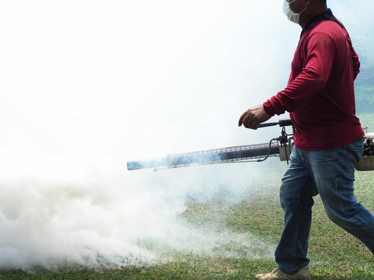 Pest control technician spraying a Cape Coral backyard for mosquito prevention.