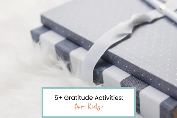 notebooks with ribbon wrapped around them and a pen on top