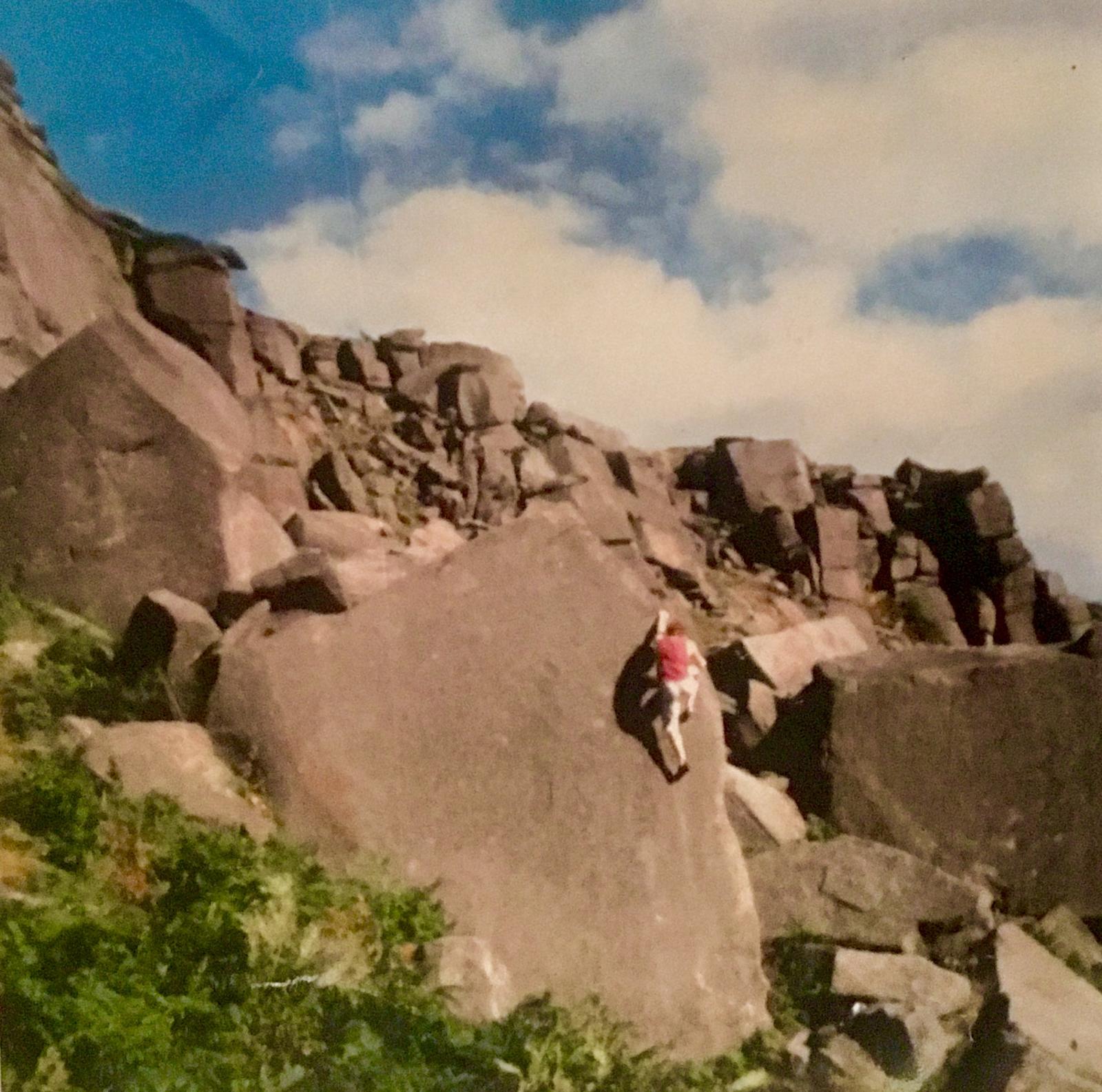 Simon Clark sitting on a cliff near his car in the Sahara Desert
