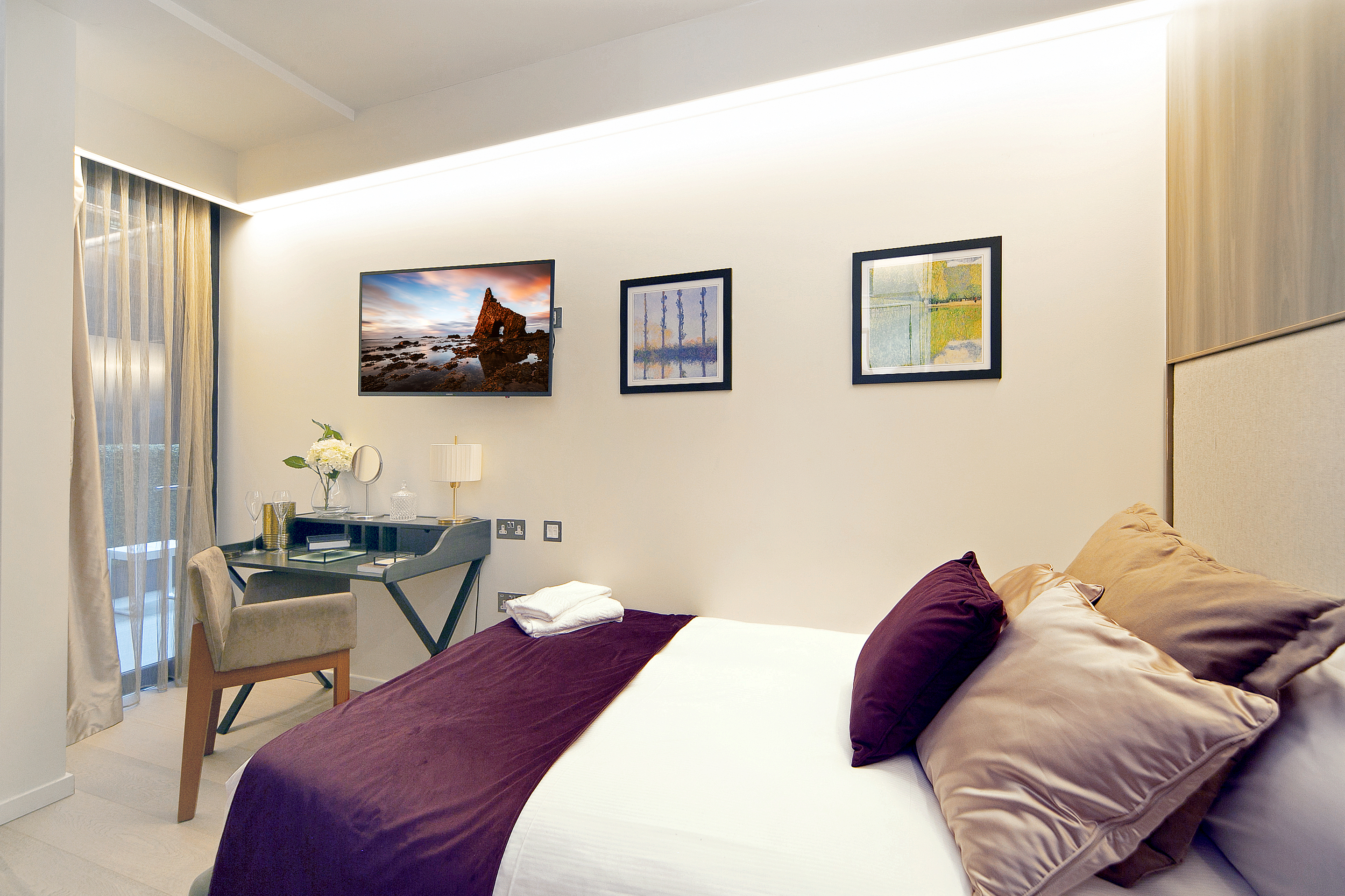 Serviced apartment bedroom with desk and contemporary furnishings