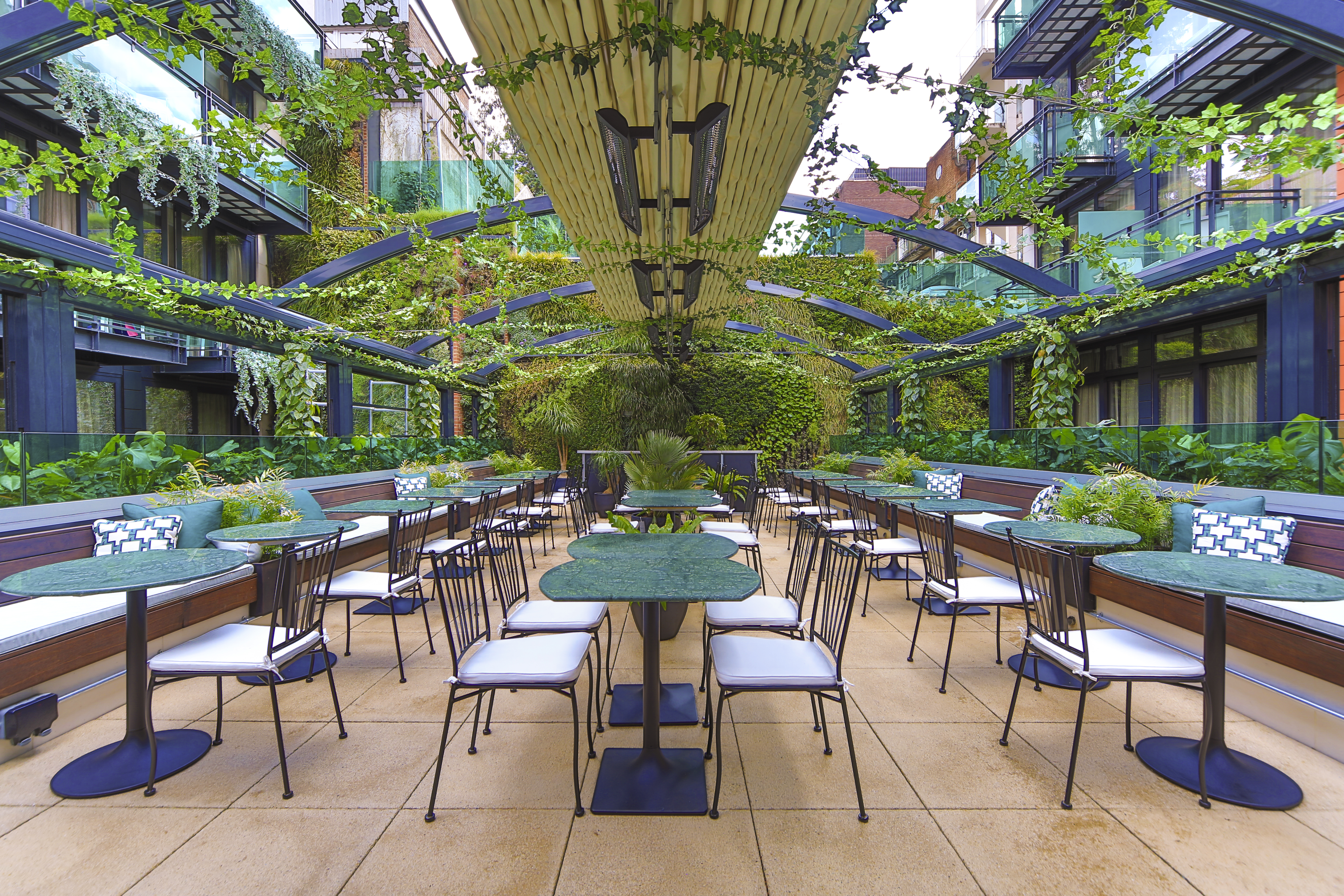 Hotel courtyard with outdoor dining tables and greenery
