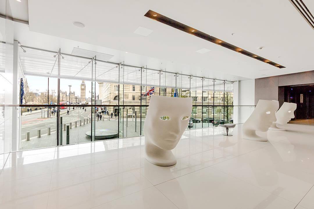 Modern hotel lobby with glass walls, contemporary art and natural light