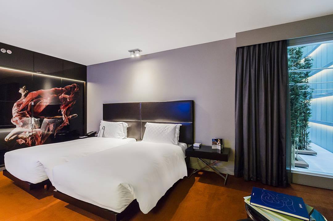 Contemporary twin hotel room with white bedding and modern interior design