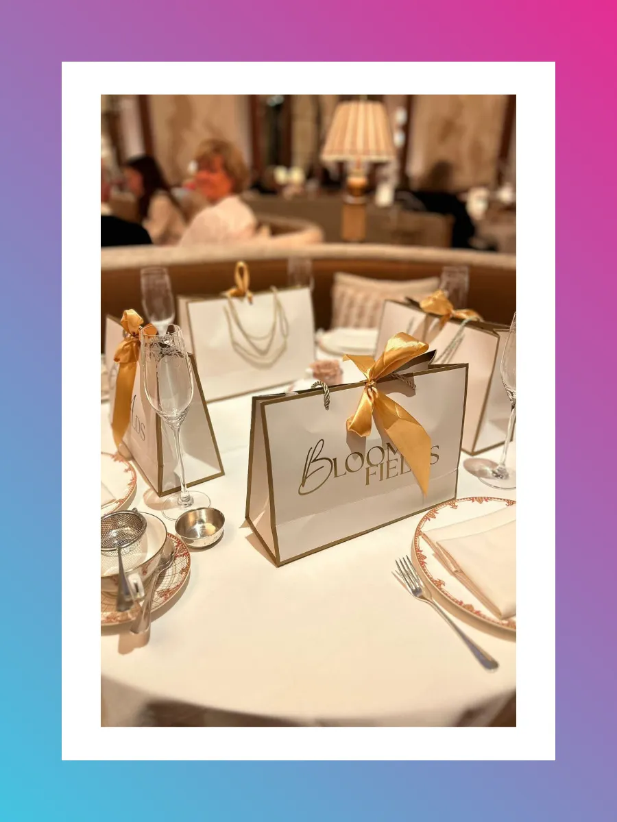 White and Gold branded gift bags on a table setting