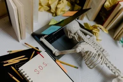 A skeleton has collapsed on a laptop.