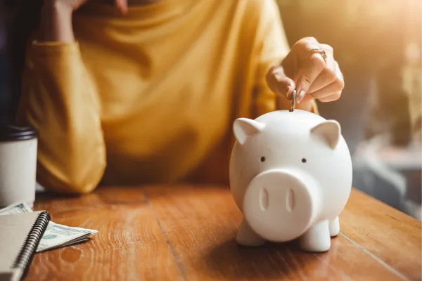 lady putting money into a piggy bank