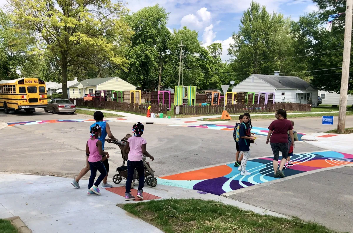 children walking across the street on a painted pavement crosswalk
