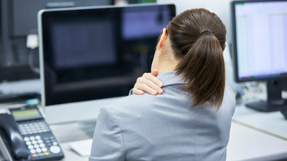 Woman with Neck Pain Sitting at Desk