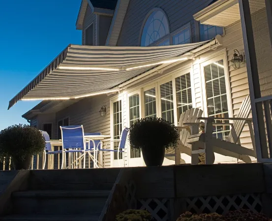  A charming house featuring a welcoming porch and a patio adorned with stylish awnings for shade and comfort.