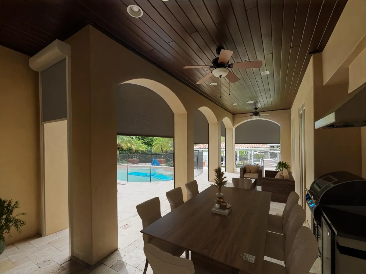 An Outdoor dining room featuring a ceiling fan and a view of a serene pool outside, creating a relaxing atmosphere. MagnaTrack 
