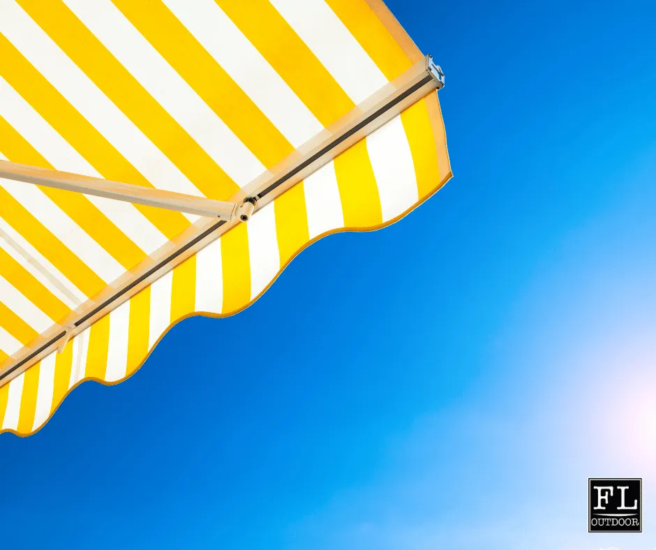 Picture of yellow and whit awning with blue skys and bright sun slowly creeping toward the noon sky.