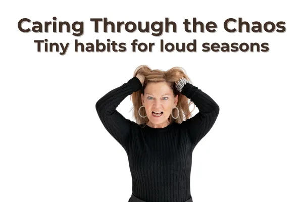 Juli Madacey stands against a white background, grabbing her hair with both hands and making a frustrated face—capturing the chaos—while wearing a black jumper and hoop earrings.