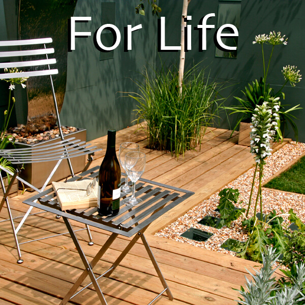 Contemporary garden seating area with natural timber decking and ornamental planting