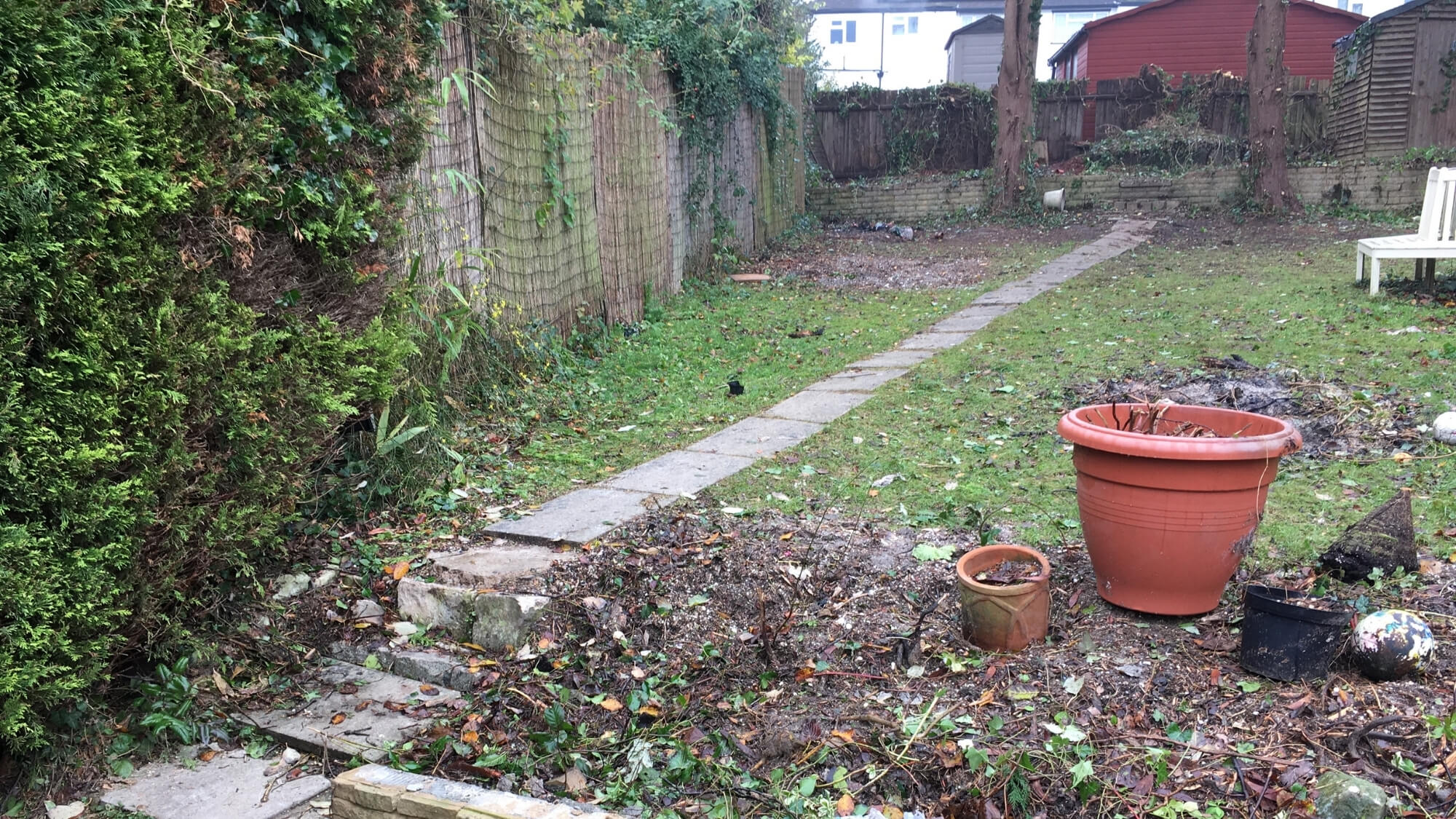 Before: neglected sloping rear garden in Carshalton with poor layout and limited flow before redesign