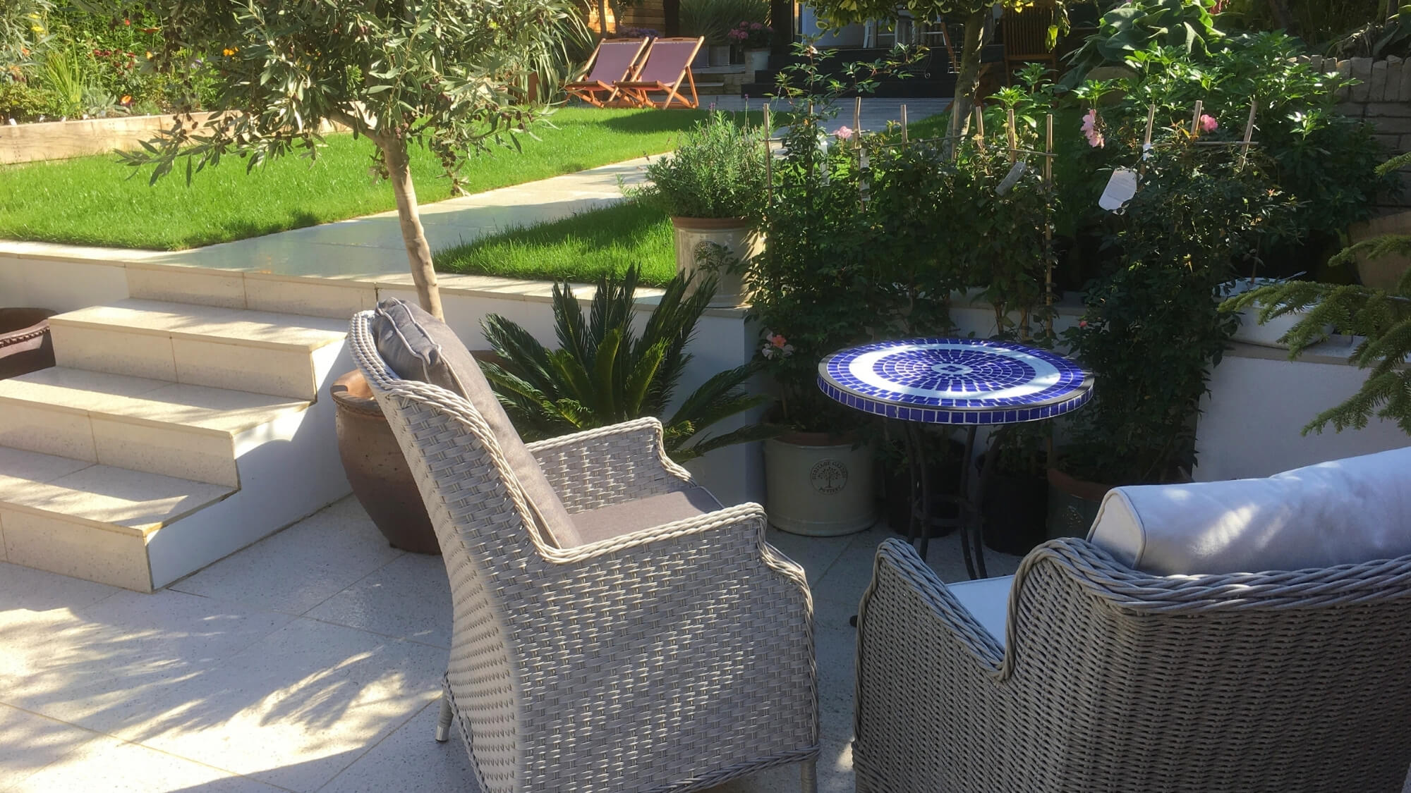 After: redesigned seating area with planting and steps in a Carshalton garden by EarthCare Gardens