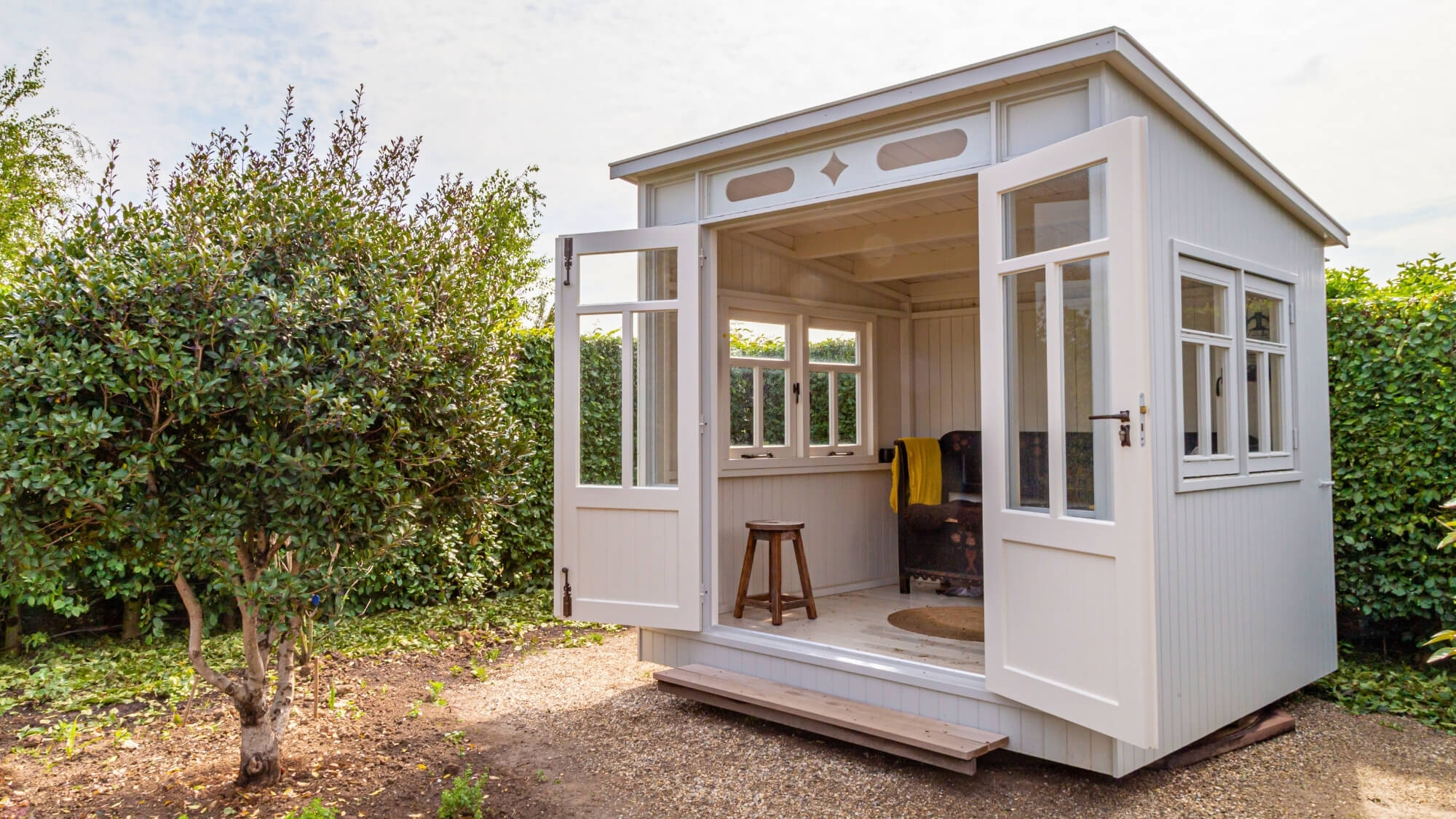 Classic garden room with opening doors and natural light, designed to complement the garden by EarthCare Gardens