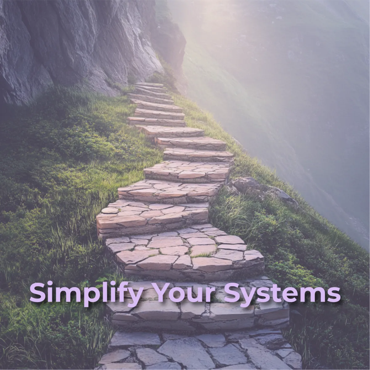 A winding stone staircase ascends a misty, grassy hillside, leading towards a bright, unknown destination at the top of the image. The text "Simplify Your Systems" is overlaid in purple at the bottom center of the image.