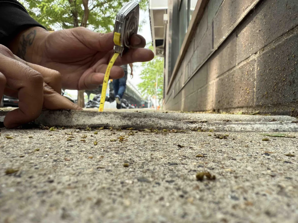measuring a raised portion of side walk where client tripped in the bronx