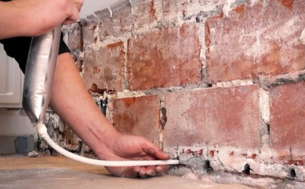 Applying chemical DPC to rising damp wall