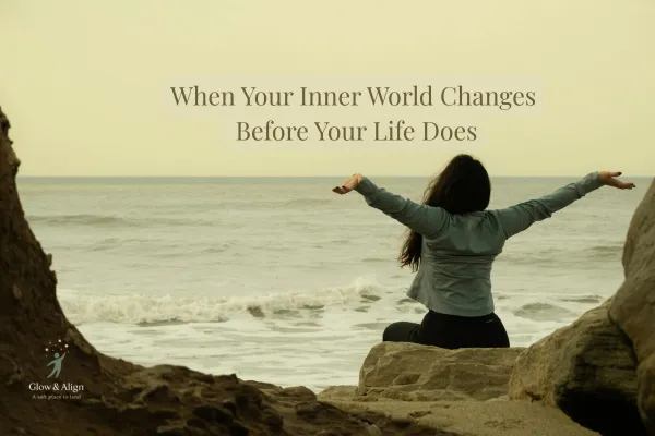 A woman sitting on a cliffside with her arms open toward the ocean, symbolizing inner clarity, emotional release, and the beginning of an identity shift.