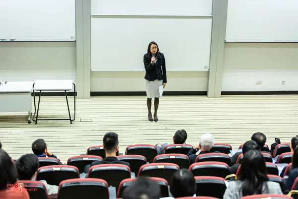 Black female professional speaking confidently at a leadership summit.