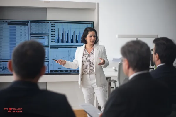 Confident woman leading a team discussion in an office meeting room.