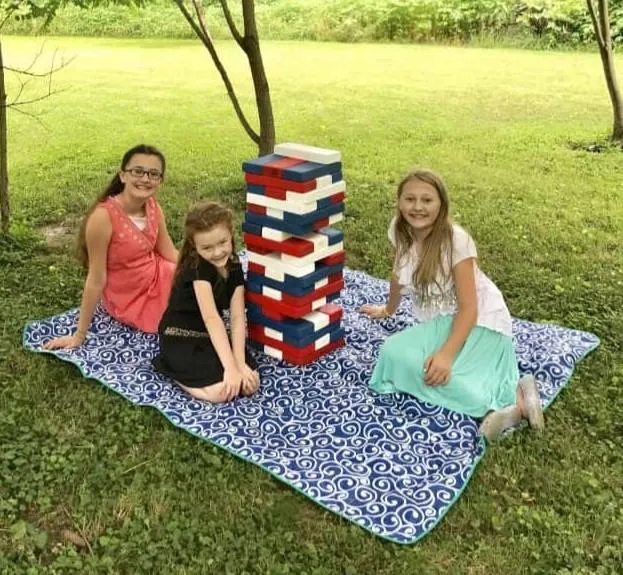 girls sitting around a large Jenga set