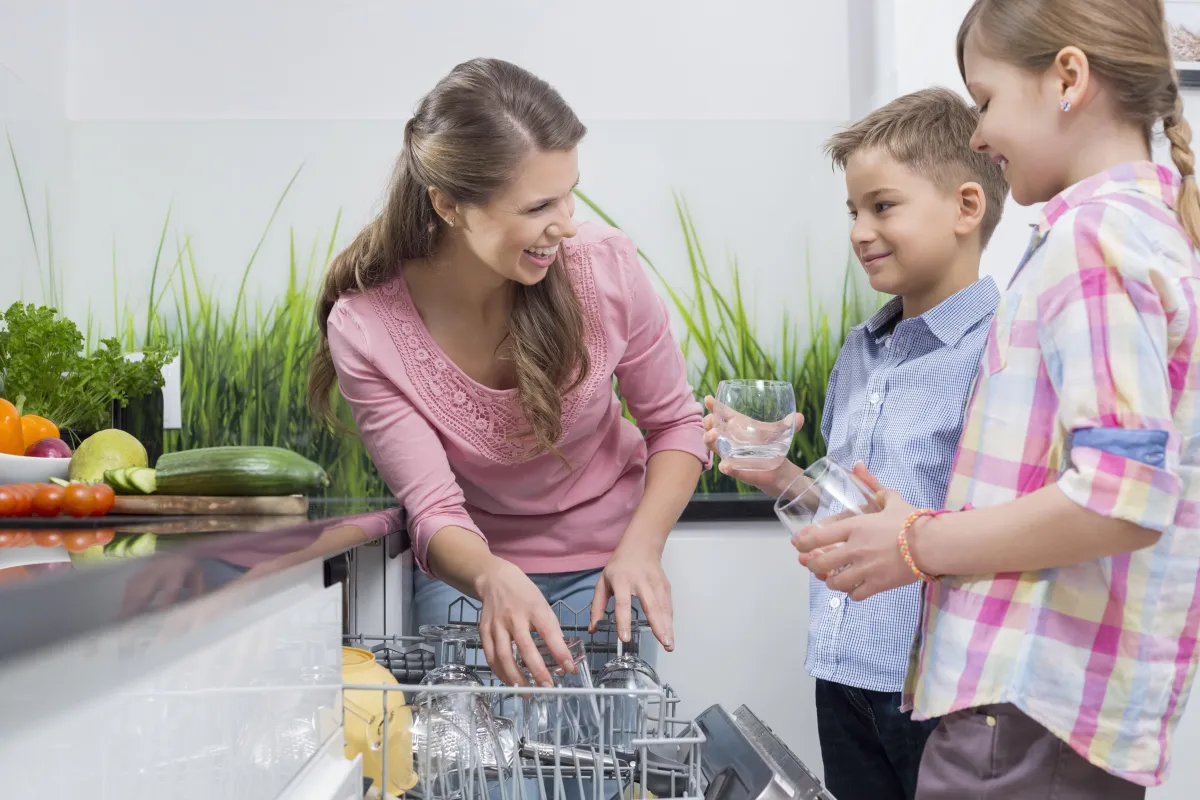 mom showing boys how to load dishwasher