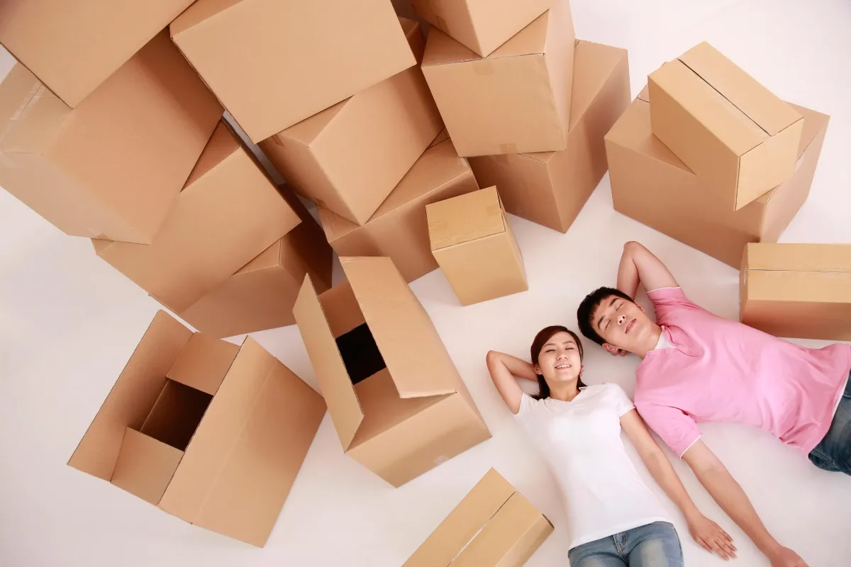 couple laying down next to stacks of boxes