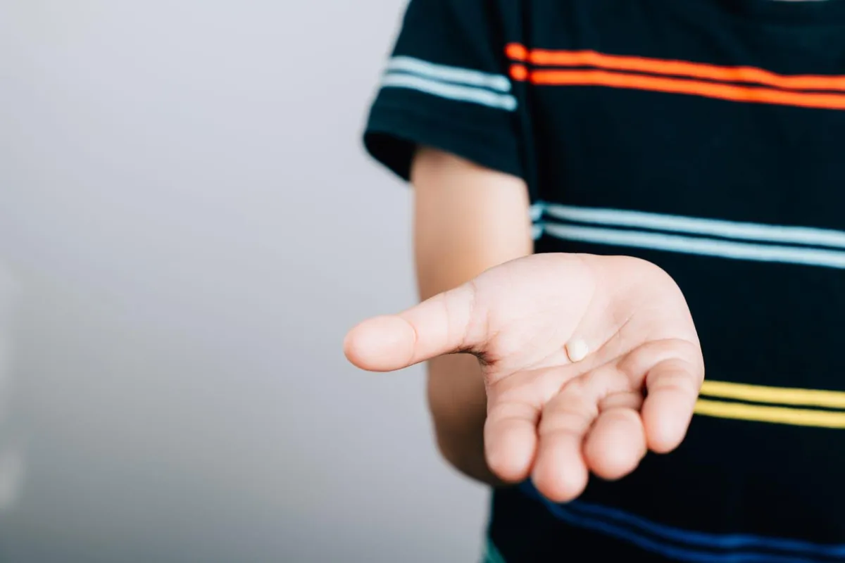 boy holding out tooth