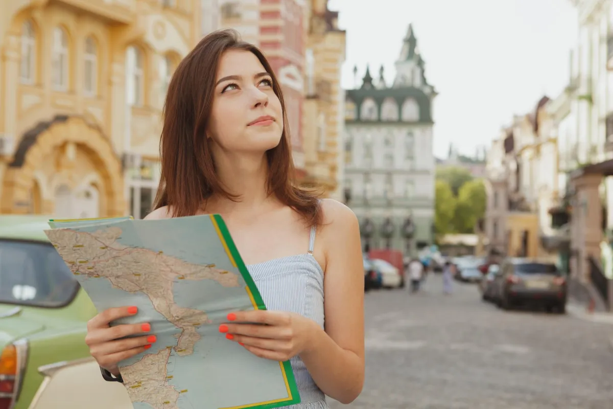 woman holding map looking at her surroundings