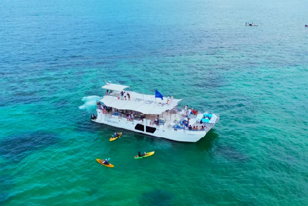 Pareja disfrutando de una escapada en catamarán frente a las islas de Cartagena, rodeados de lujo, mar azul y paisaje natural caribeño.