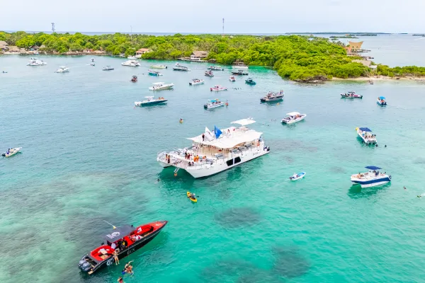 Pasajero recostado en la red del catamarán con el mar de fondo y ojos cerrados