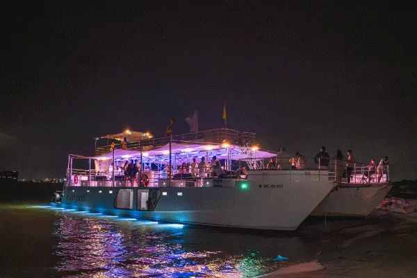 Pareja celebrando con invitados en un catamarán de lujo frente a Cartagena.