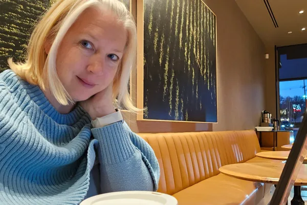 Mother sitting with coffee, reflecting on how to reclaim her time and energy.