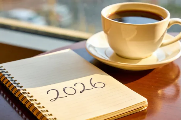Notebook marked “2026” next to a cup of coffee, symbolizing intention-setting for the year ahead.