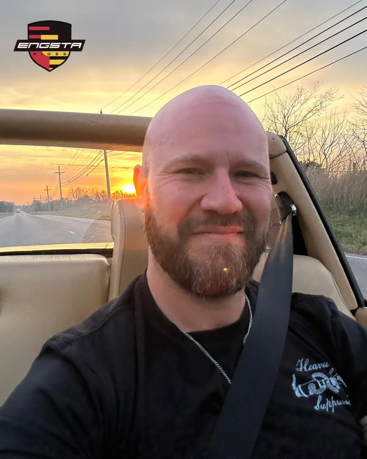 Martin Engster driving his classic Porsche 914 with the targa top off with the sun setting behind him in the Osage Countryside