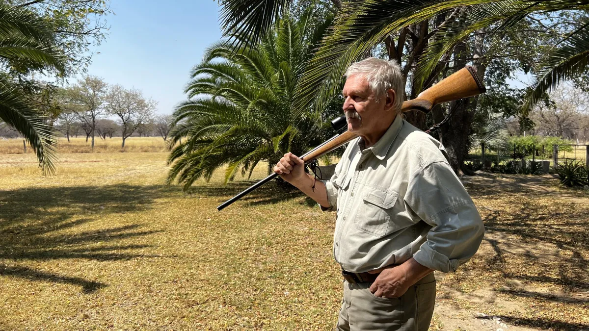 Michael Albert Engster carrying his rifles on his shoulder in Africa