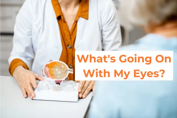 An ophthalmologist is consulting with a senior patient, using a model of the human eye to explain a condition or procedure. The doctor, wearing a white coat and an orange shirt, is gesturing towards the eye model to illustrate their point, while the patient listens attentively. The focus is on the interaction and the educational aspect of the consultation.