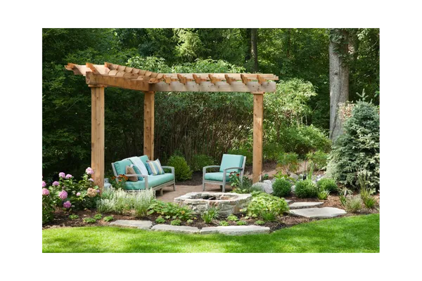 Cozy outdoor seating area under a gazebo surrounded by trees, featuring a fire pit and comfy furniture — perfect for peaceful retreats and slow living moments at Sunday Cottage Escape.
