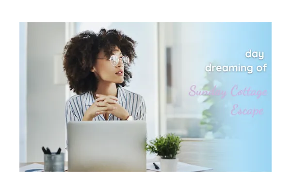 Woman sitting at a cozy desk with an open laptop, happily daydreaming out the window, symbolizing peaceful living and mindful moments.