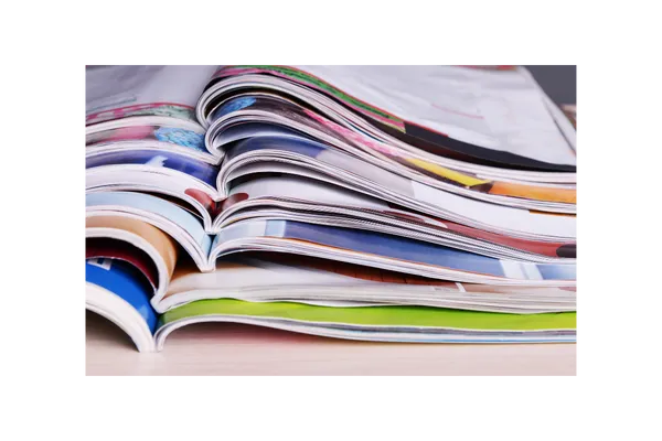 Stack of open magazines with calming colors and rustic designs inspiring the vision for Sunday Cottage Escape, a peaceful Arizona retreat.