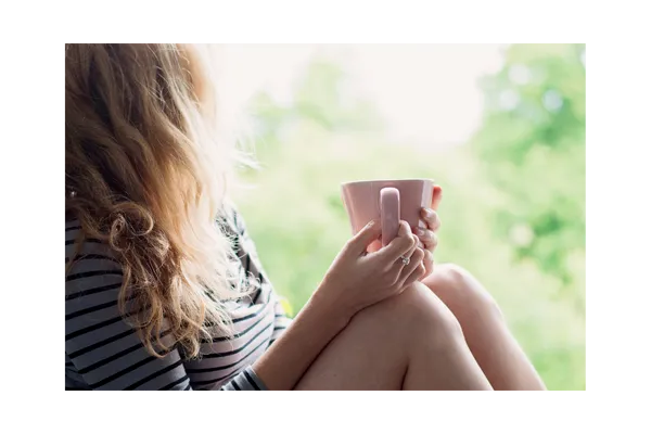 Woman peacefully resting in a hammock surrounded by nature, representing relaxation, slow living, and stress relief.