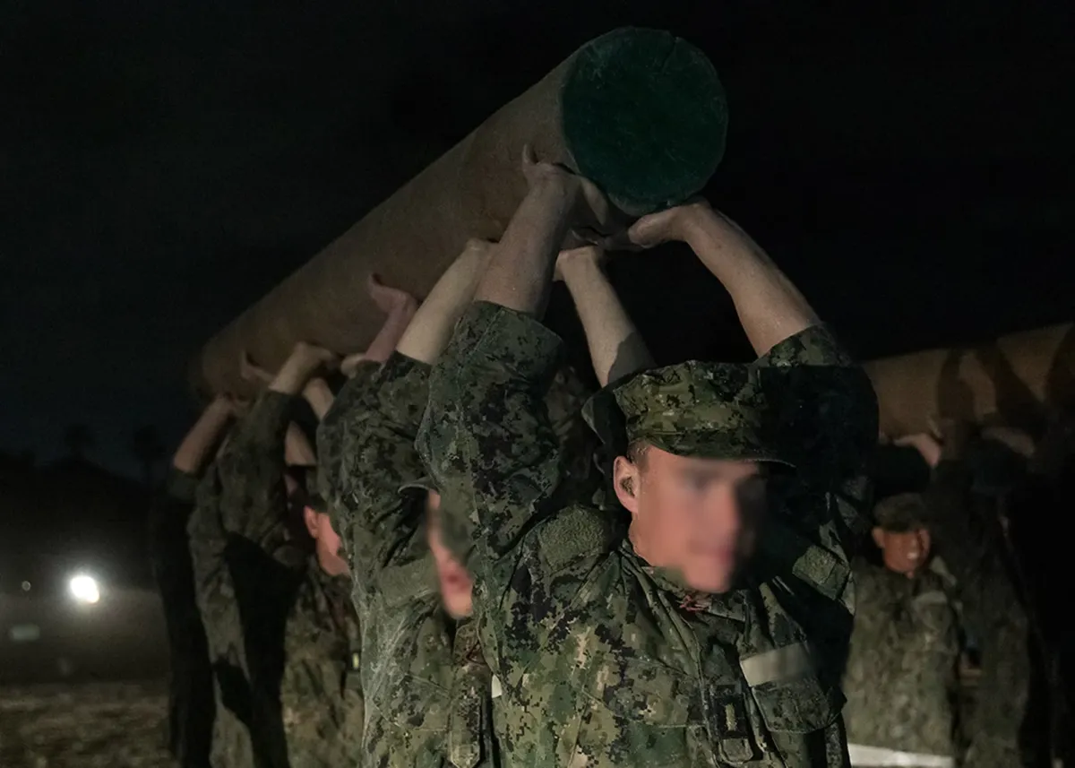 Tactical athlete performing a loaded carry, combining mechanical and metabolic stress