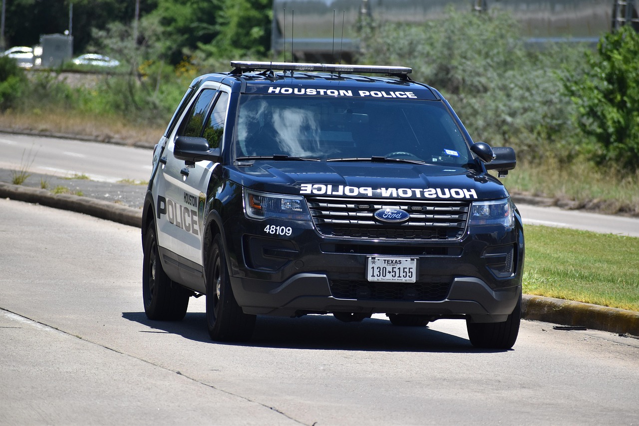 police patrol vehicle driving down the street during a sunny day