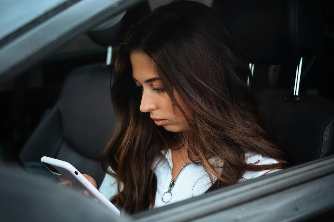 Woman sitting in parked car looking stressed representing the moment of financial crisis and overwhelming debt realization
