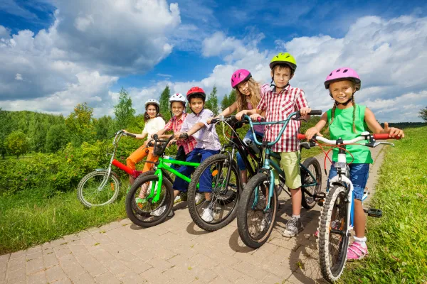 Image of children wearing helmets and protective gear while playing or engaging in activities.